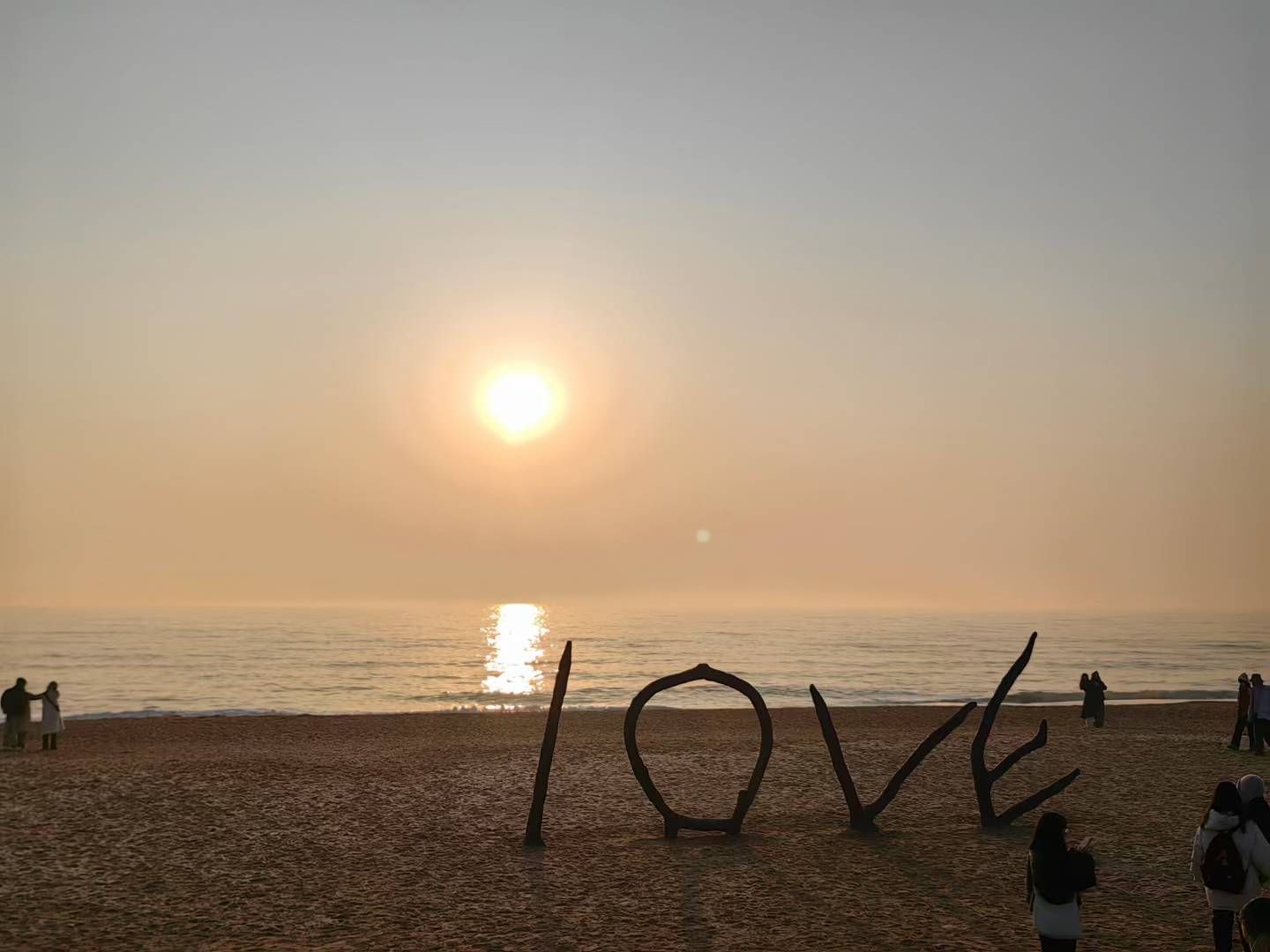 LOVE sculpture on a beach at sunset