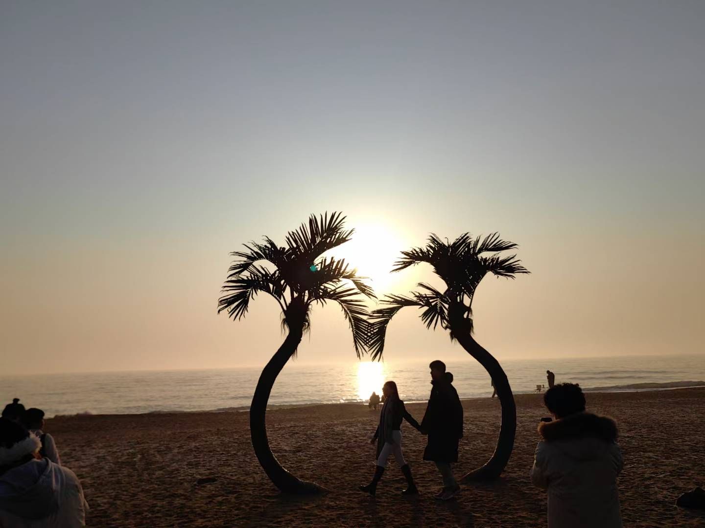 Heart-shaped palm silhouette by the sea